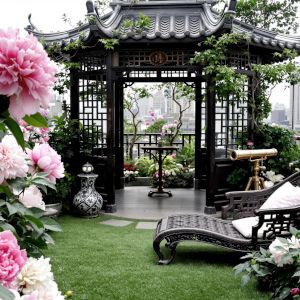 A beautiful roof top garden with small, well-trimmed lawn, lounger, and Chinese-style pergola