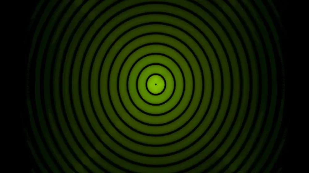 A lime-green circle with a black dot center, surrounded by concentric circles of black and green fading in intensity toward the outside